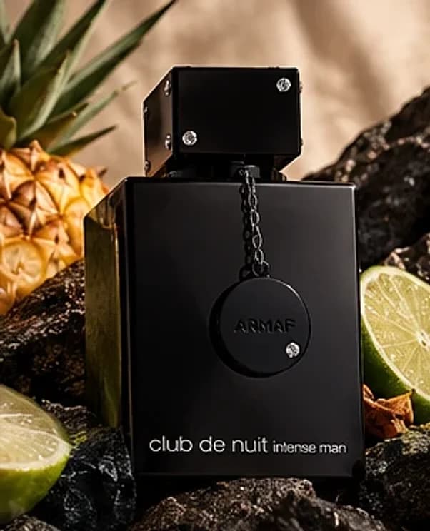 Frasco preto do Armaf Club de Nuit Intense Man 105ml sobre pedra com limão e abacaxi