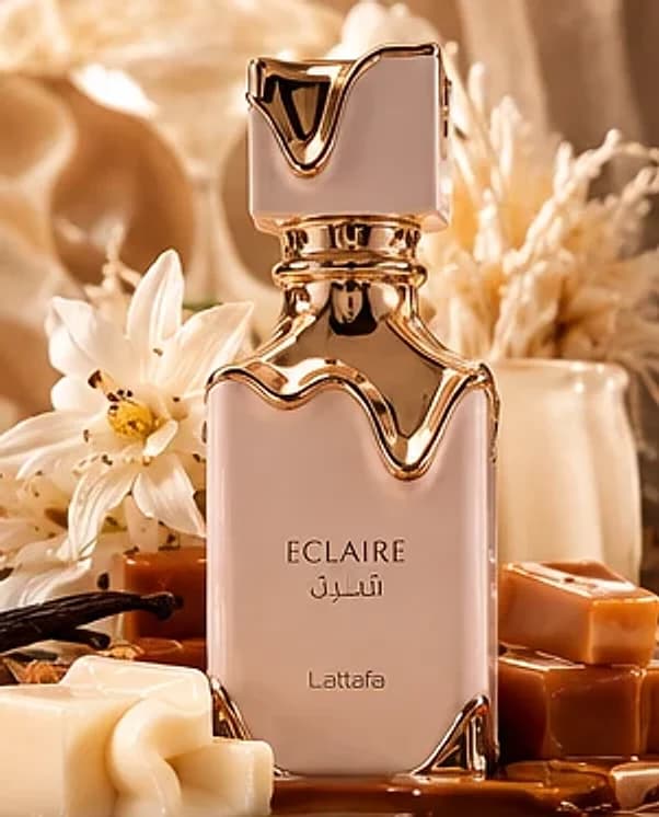 Frasco creme com tampa dourada do Lattafa Eclaire 100ml com caramelo e flores brancas